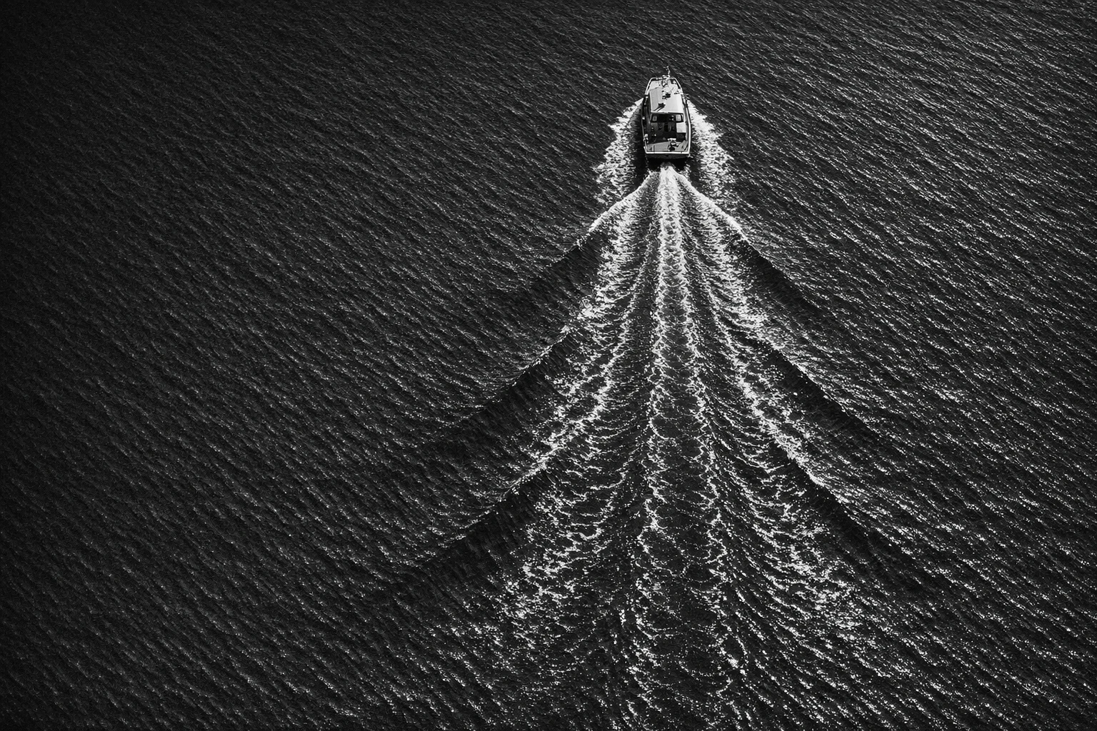 A survey craft leaving a directional wake across dark water